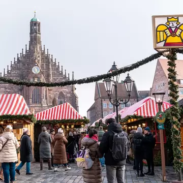 A crowd of people at the Christmas Market at the famous Nurnberg or Nuremberg, Germany. View of Hauptmarkt square and Church of Our Lady (Frauenkirche). 