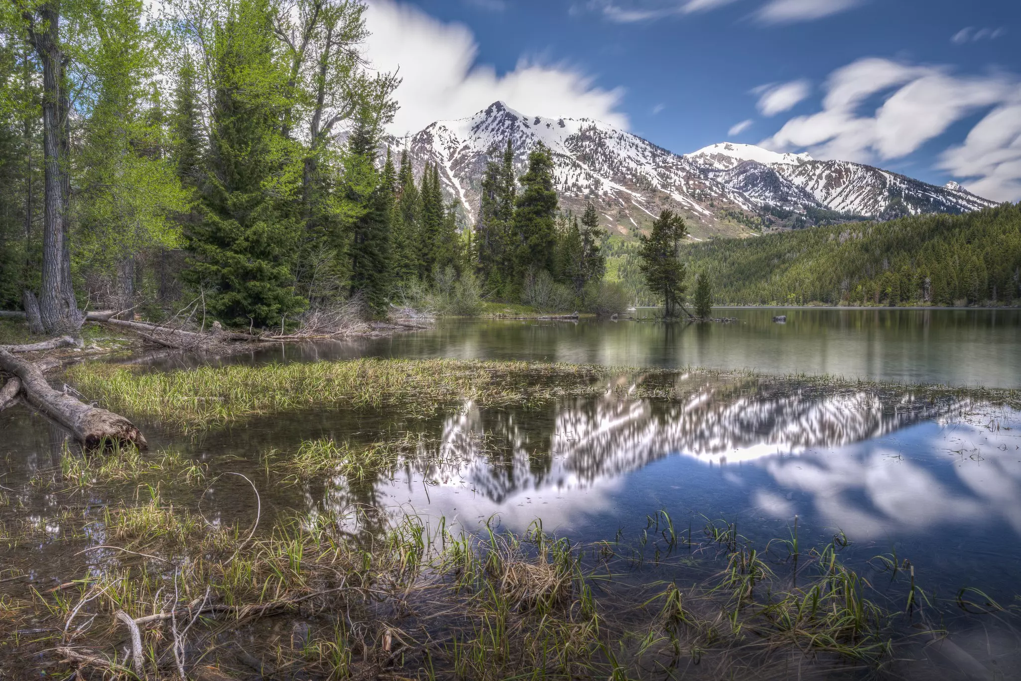 A large lake backed by mountains and surrounded by woodland