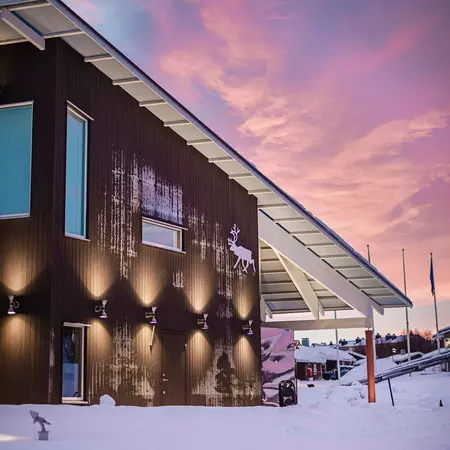 brown building with sloped roof under a pink sky