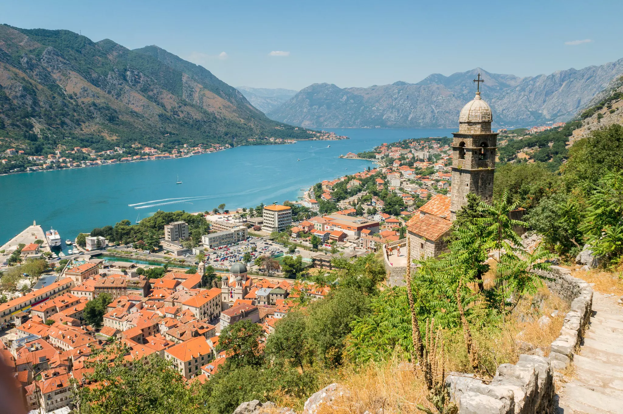 City walls and steps lead up to a view over a lakeside city