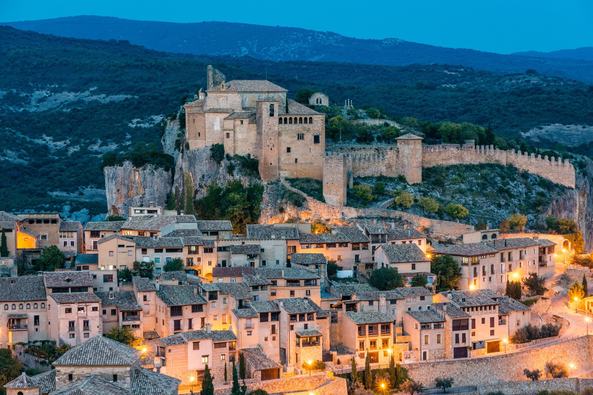 View of the former fortress, now housing the Colegiata de Santa María, at night in Alquézar, Spain.
