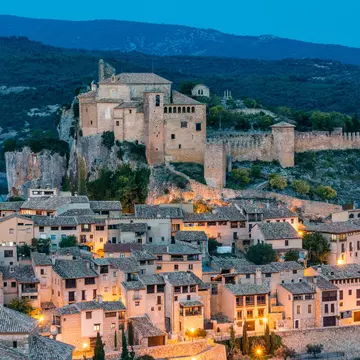 View of the former fortress, now housing the Colegiata de Santa María, at night in Alquézar, Spain.