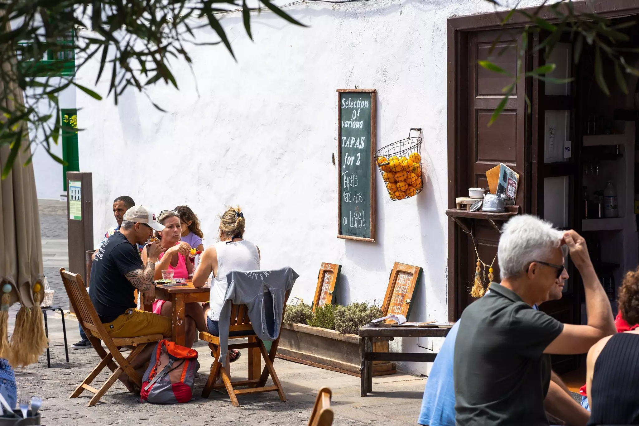 Diners sit at open-air tables on a rooftop overlooking Porto
