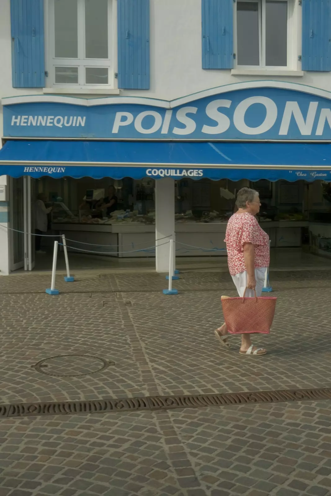 A woman walks by a fish shop on Île d'Yeu in the Vendée region of France