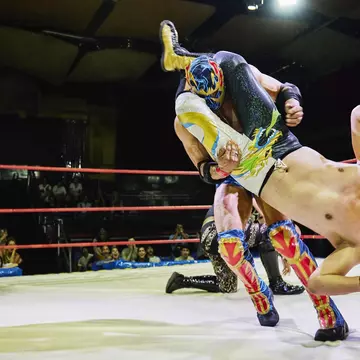 A luchador throwing an opponent to the mat