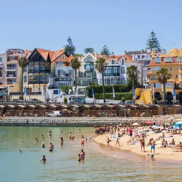 People swimming on Praia da Ribeira on a sunny day in the town of Cascais in Portugal.