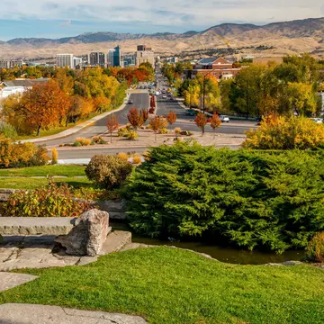 Fall trees with autumn colours line the streets of a low-rise city in a mountainous region