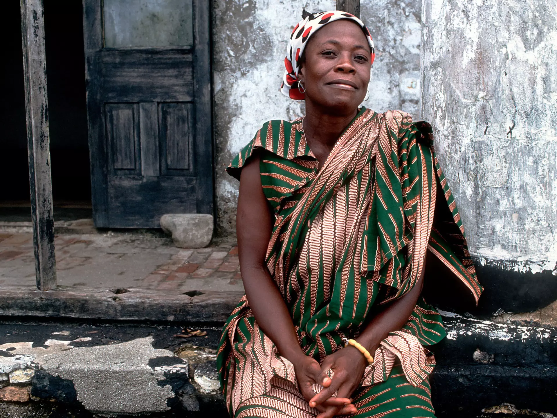A Ghanaian woman poses for a photo close to Elmina Castle in Ghana.