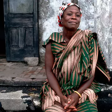 A Ghanaian woman poses for a photo close to Elmina Castle in Ghana.