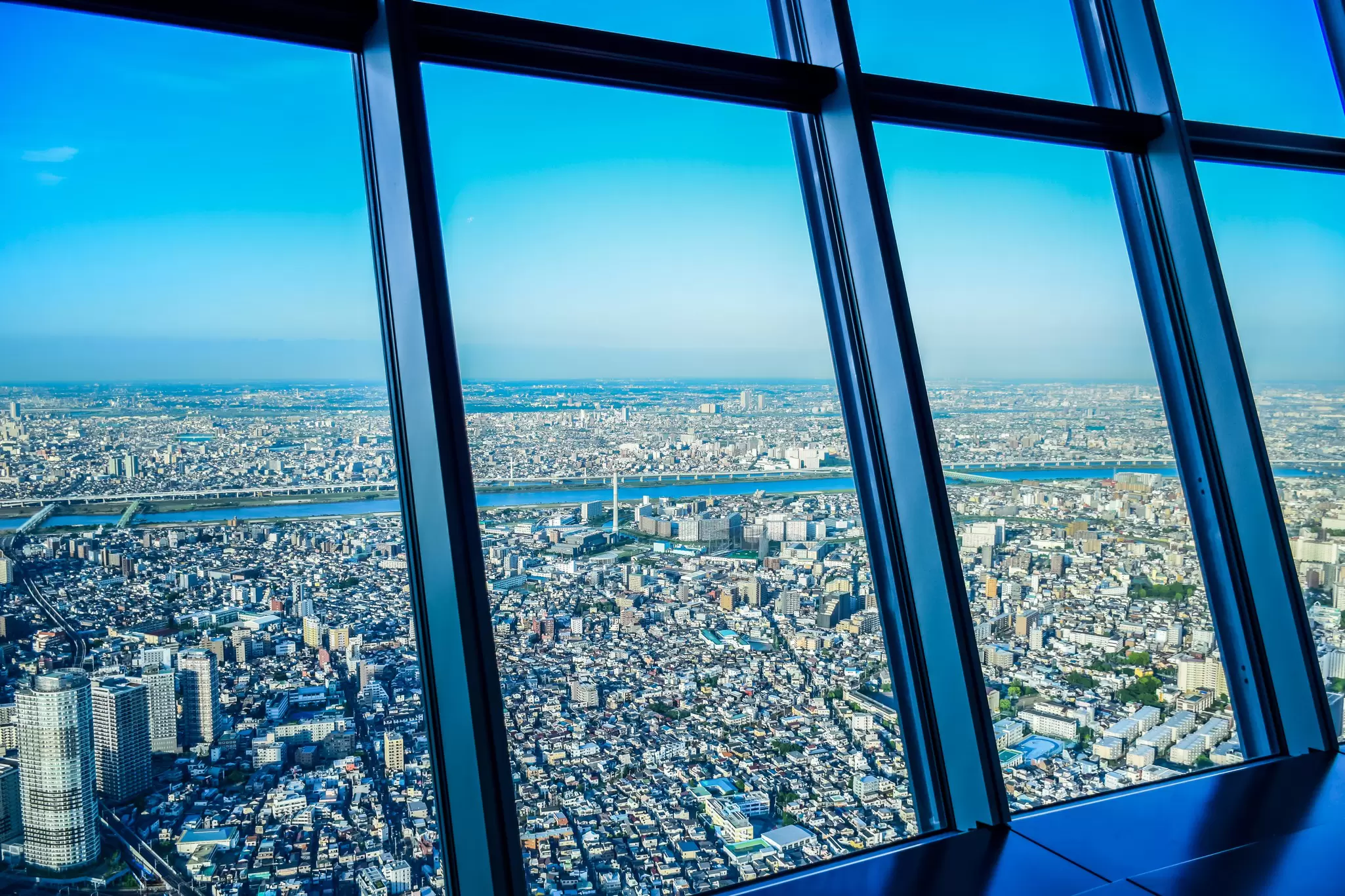 Aerial view of Tokyo cityscape through Tokyo Skytree Tower windows.