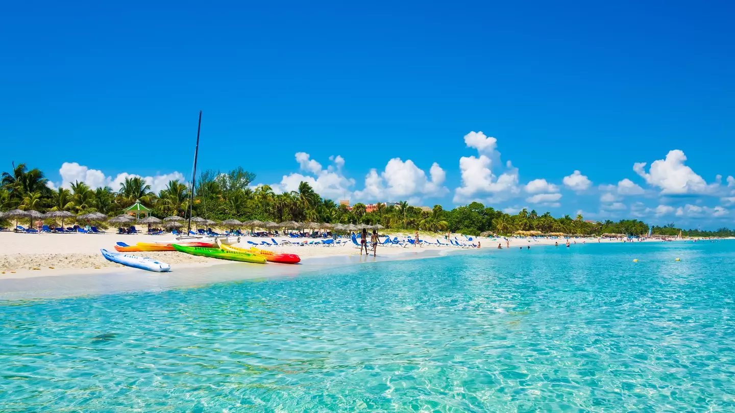 The beautiful beach of Varadero in Cuba with colorful boats and thatched umbrellas (image taken from the sea).