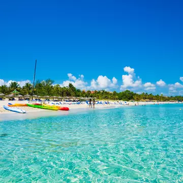The beautiful beach of Varadero in Cuba with colorful boats and thatched umbrellas (image taken from the sea).
