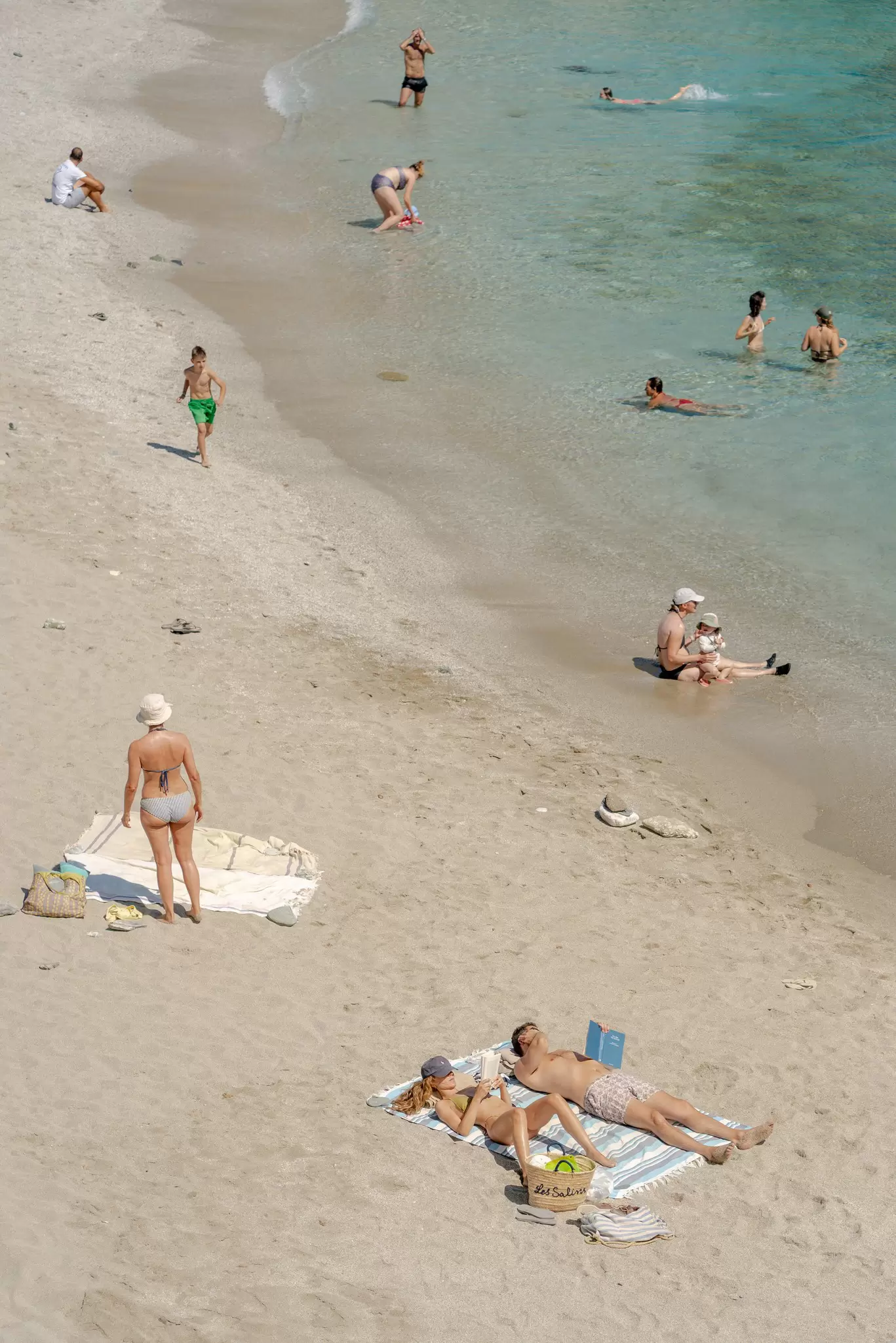 People enjoying the beach and the sea on Folegandros Island, Greece. 