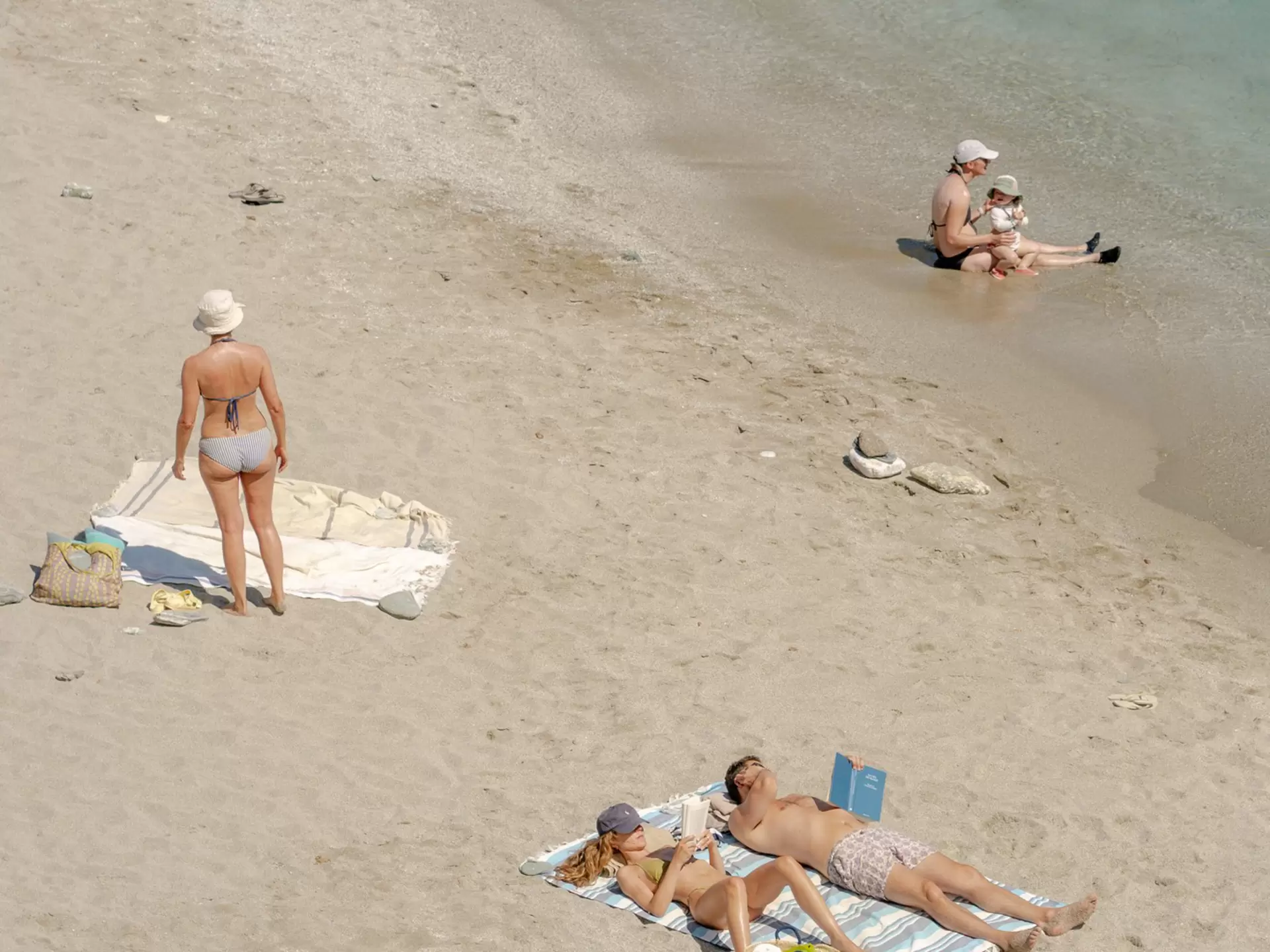 People enjoying the beach and the sea on Folegandros Island, Greece. 