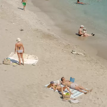 People enjoying the beach and the sea on Folegandros Island, Greece. 