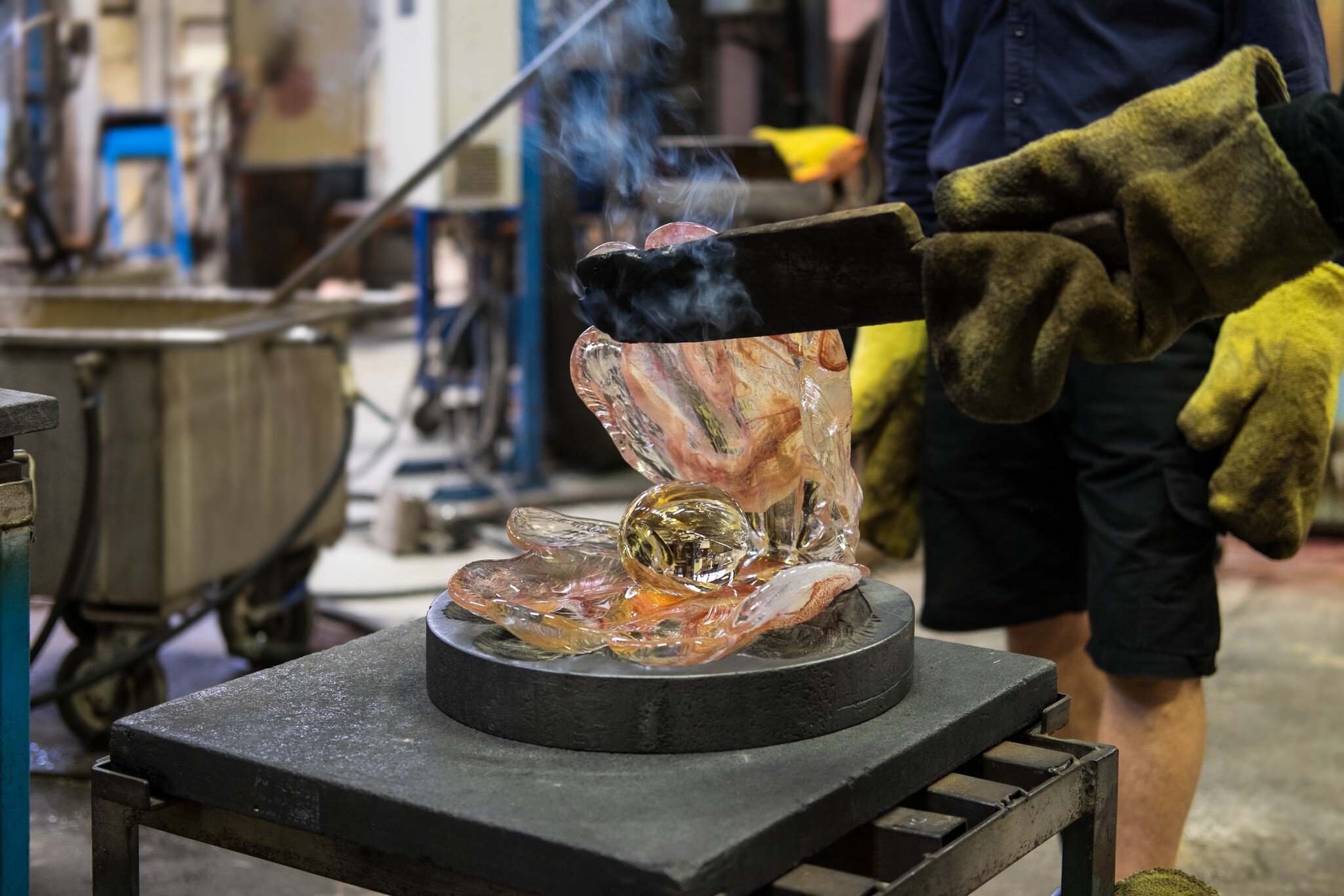 KOSTA, SWEDEN - MARCH 12 2020: Man makes a glass shell with a pearl out of just blown liquid and glowing hot colored glass in Kosta glassworks in Sweden; Shutterstock ID 1685666926;
