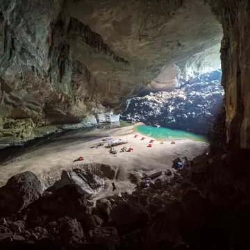 Tents set on the beach inside a large cave, Hang En cave, Vietnam
