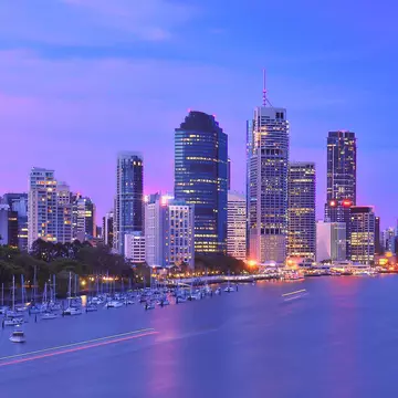 Illuminated waterfront cityscape under purple sky, Brisbane, Australia
