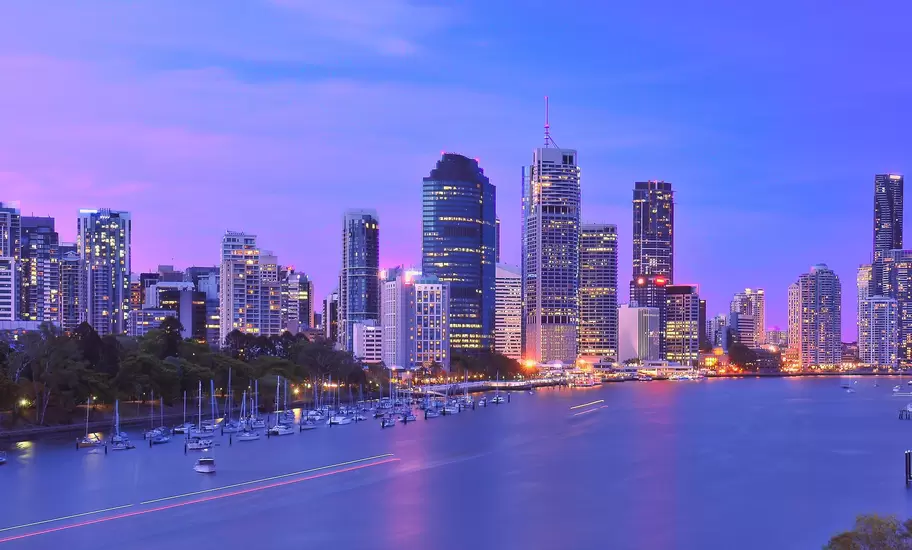 Illuminated waterfront cityscape under purple sky, Brisbane, Australia