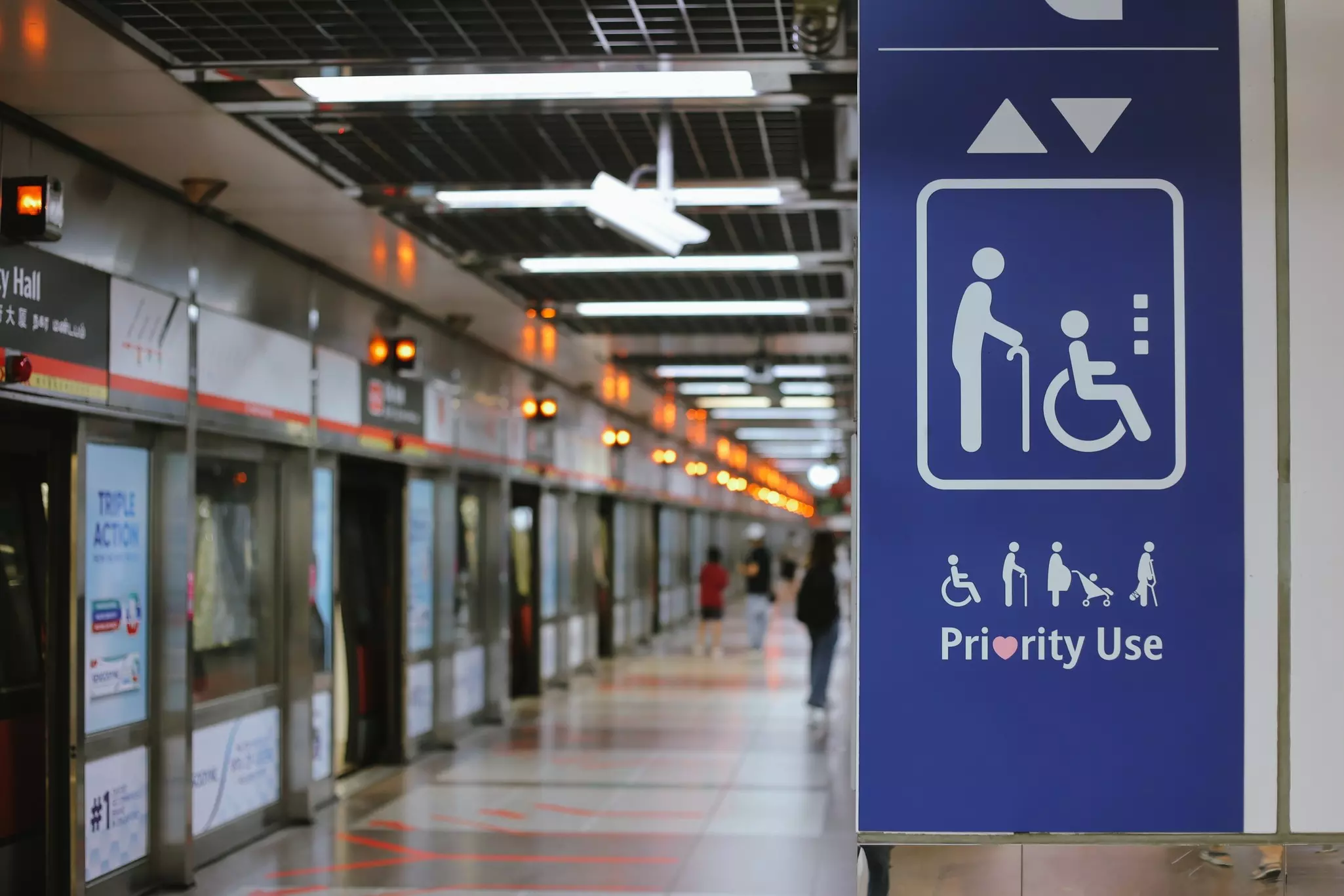 A sign with icons indicating wheelchair-users, people who use walking support, pregnant people and those with children and text that reads "Priority Use"