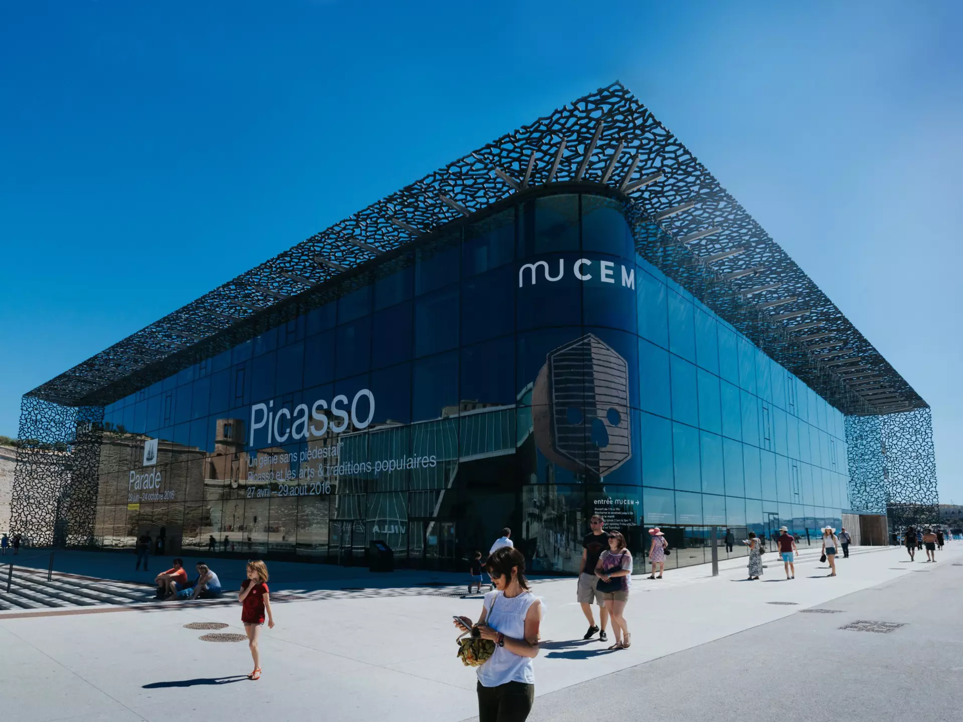 The large glass-and-steel exterior of MuCEM, with people walking by