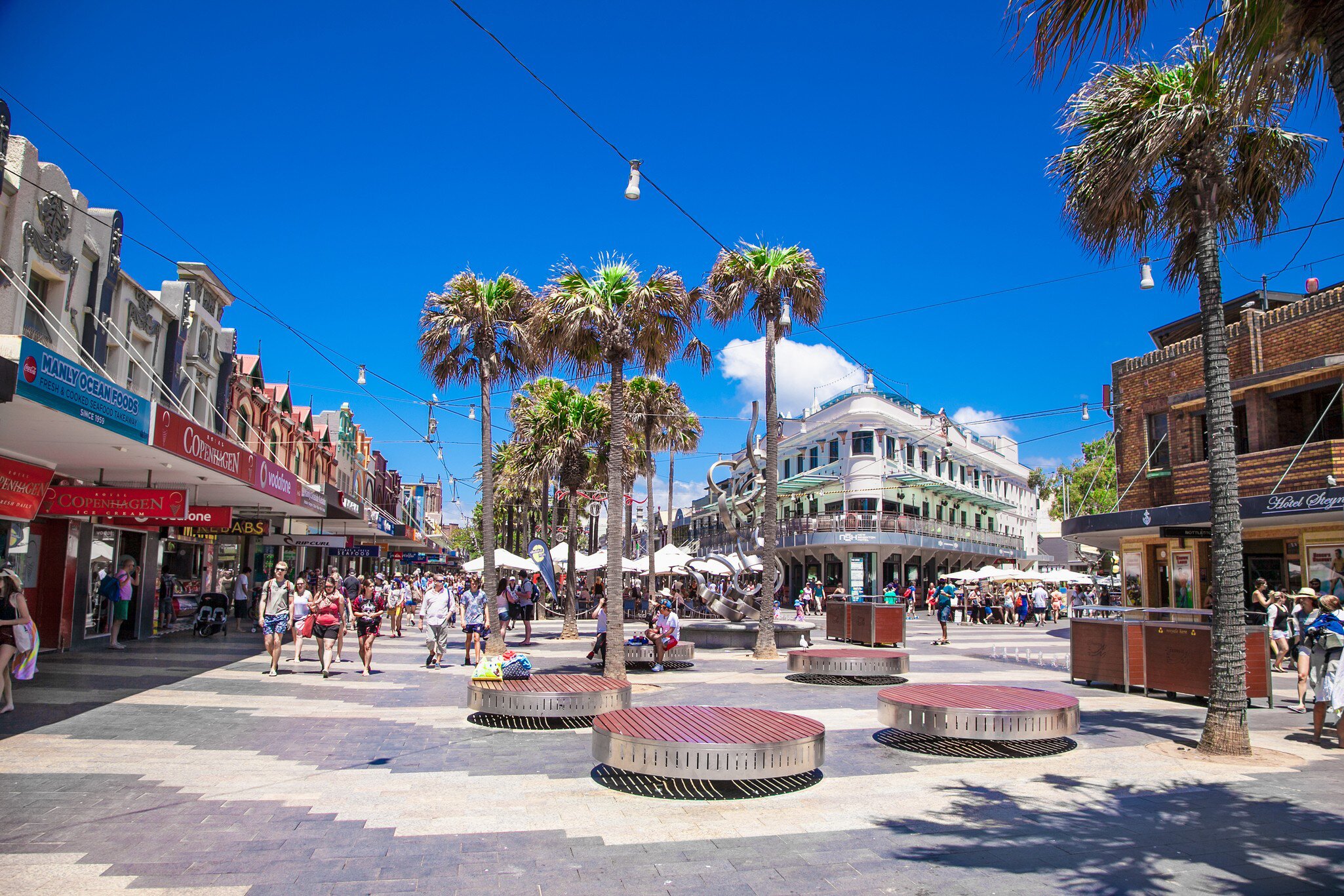 People walking through the shopping area named The Corso in Manly. Sydney, Australia.