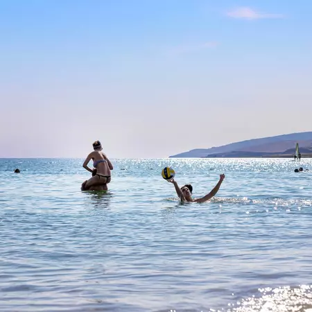Group of cheerful friends playing in the sea.