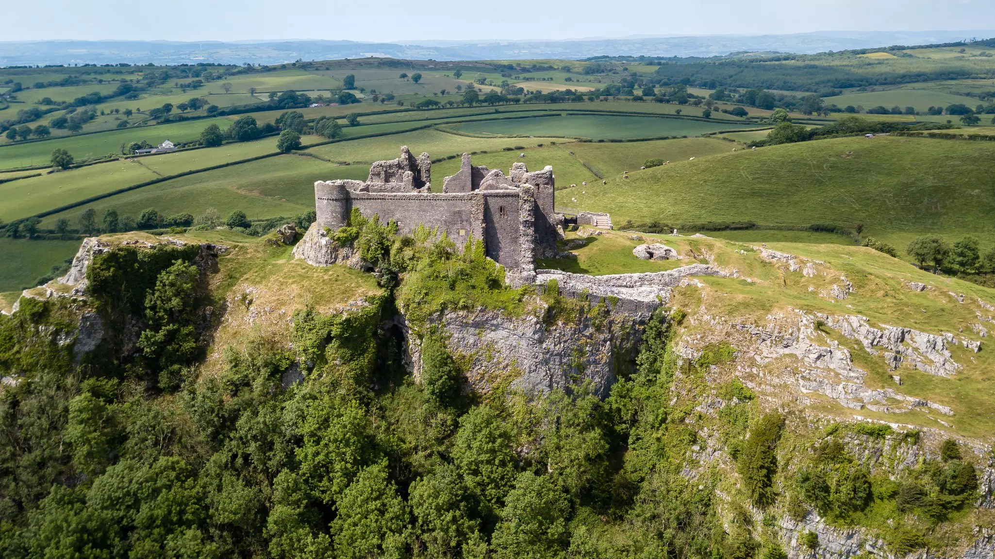 Aerial view of the ruins of Carreg Cennen castle and the surrounding fields, in Wales.