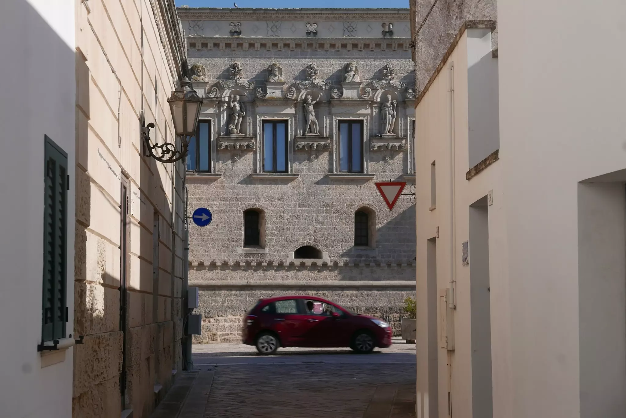 A baroque castle facade with a car in front of it in Corigliano d'Otranto