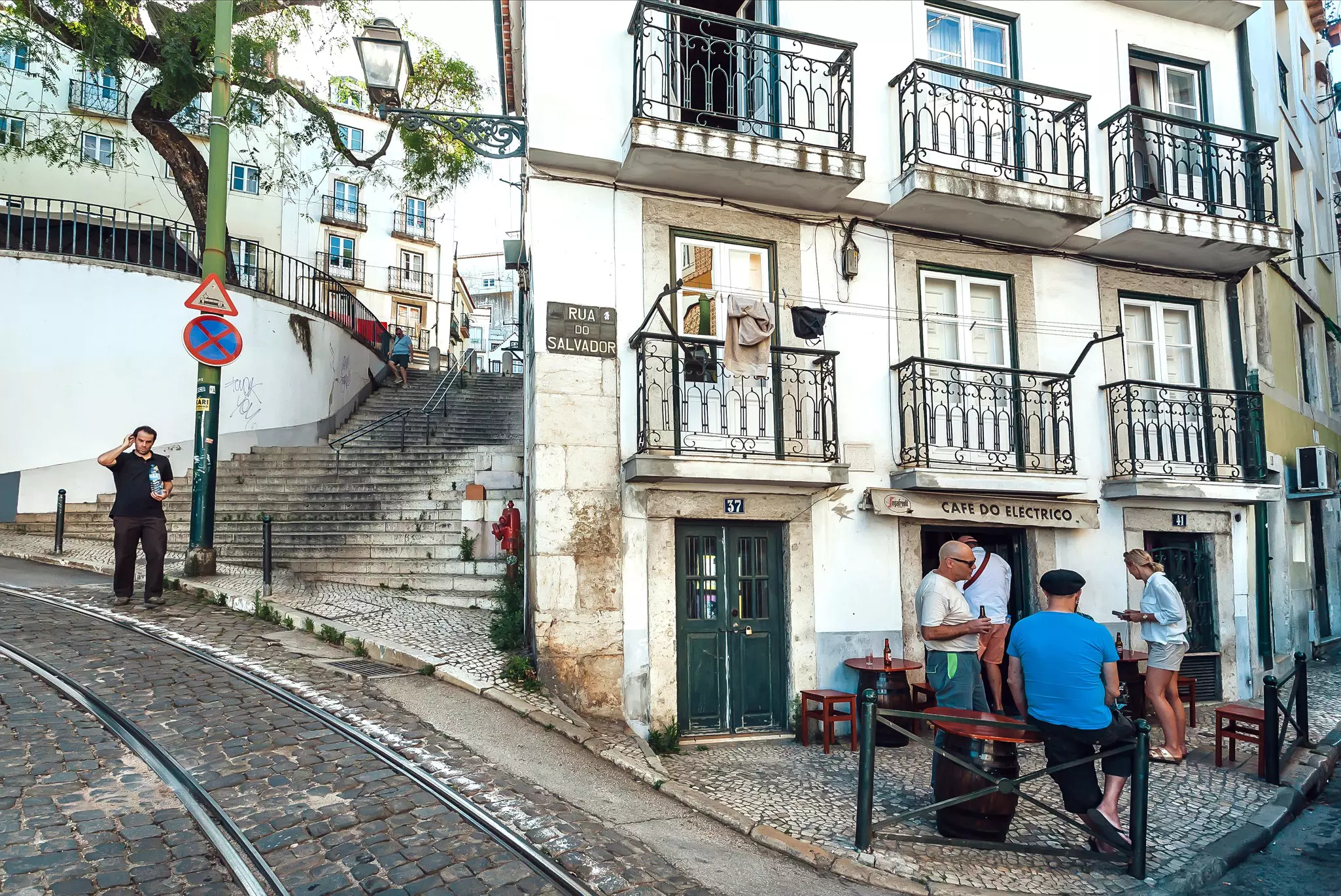 LISBON, PORTUGAL: People meeting and drinking beer and wine outside the bar on cobbled street of old city on May 14 2019. Alfama is the oldest district of Lisbon city  License Type: media  Download Time: 2021-09-15T12:09:25.000Z  User:   Is Editorial: Yes  purchase_order:   