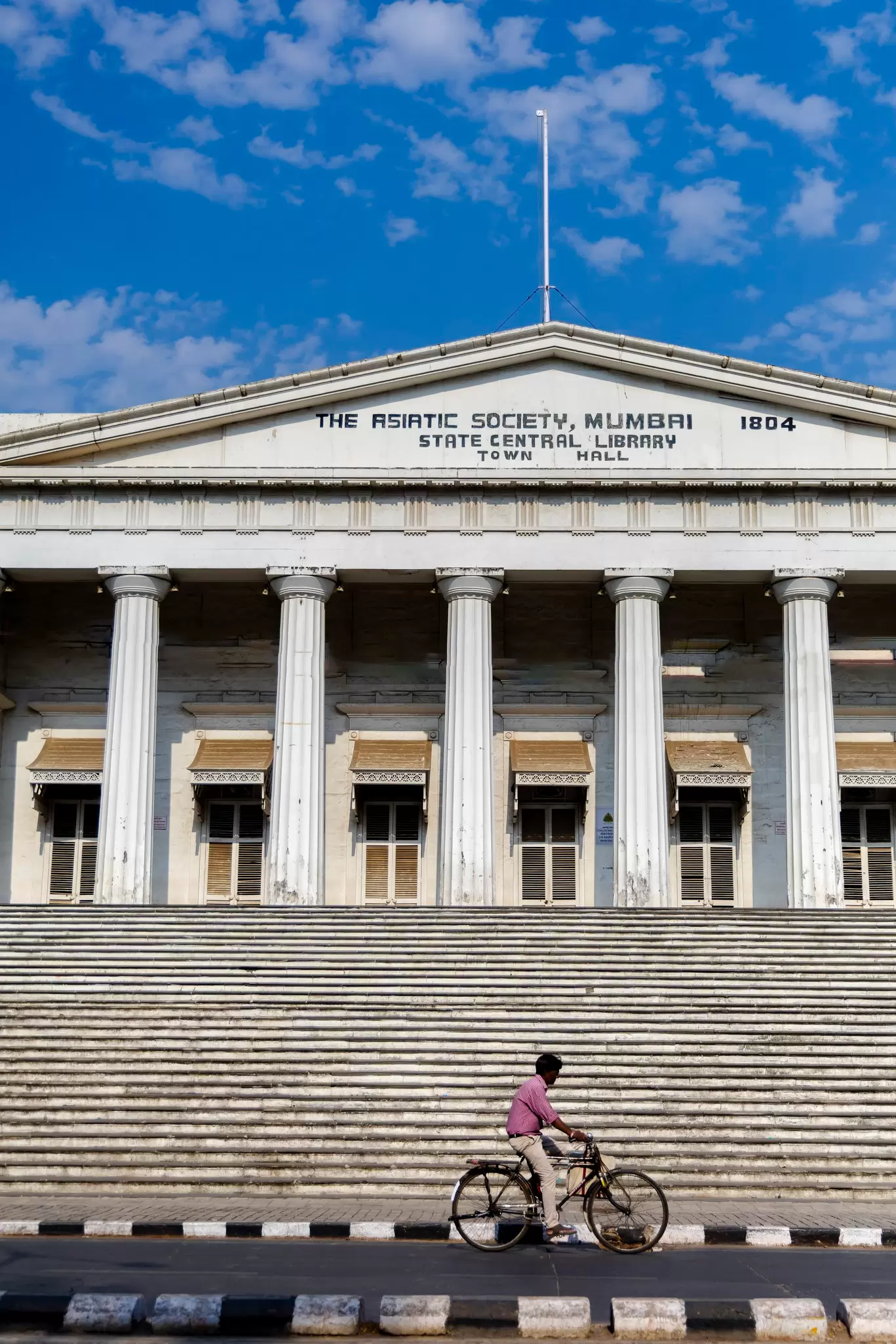 A man cycles past the Asiatic Society library 