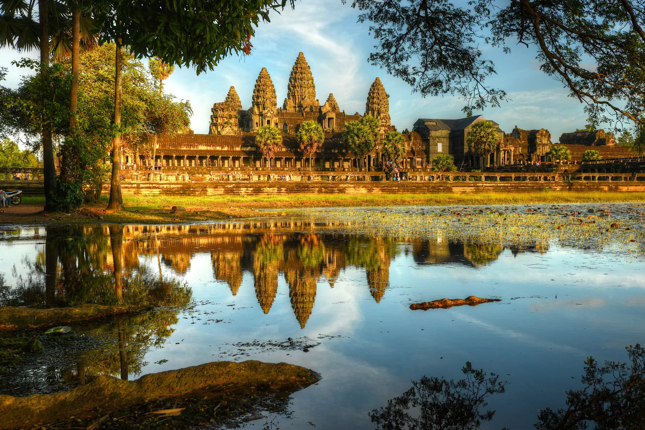 A large temple complex reflected in a nearby lake.