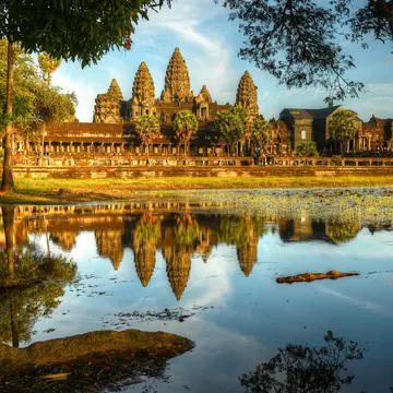 A large temple complex reflected in a nearby lake.