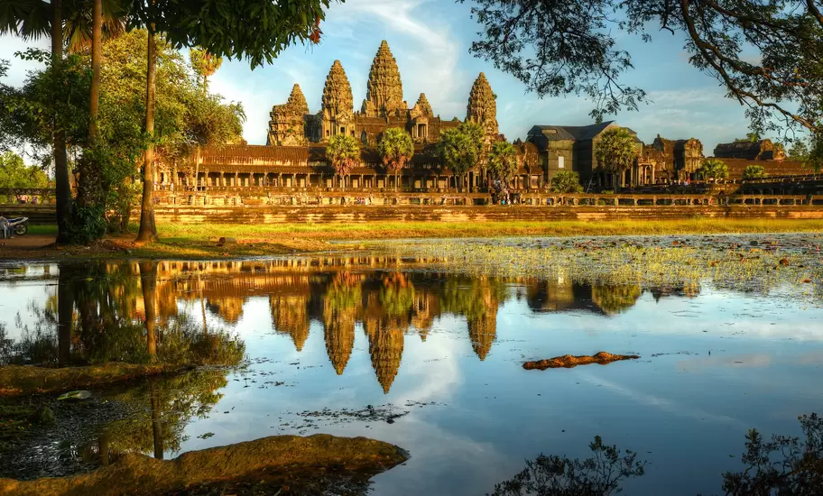 A large temple complex reflected in a nearby lake.