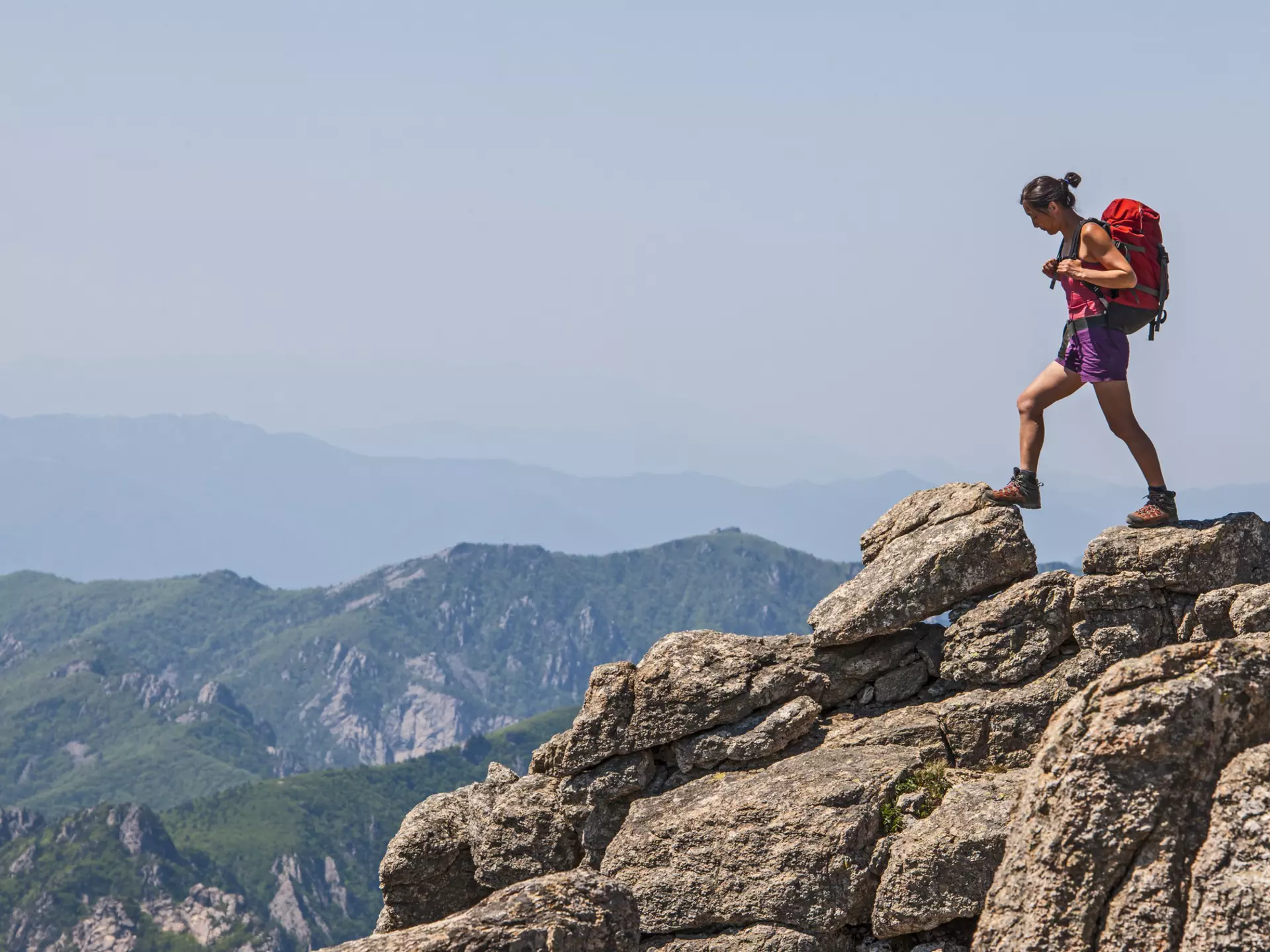 A woman walks across rocky terrain towards Daecheongbong peak at Seoraksan national park