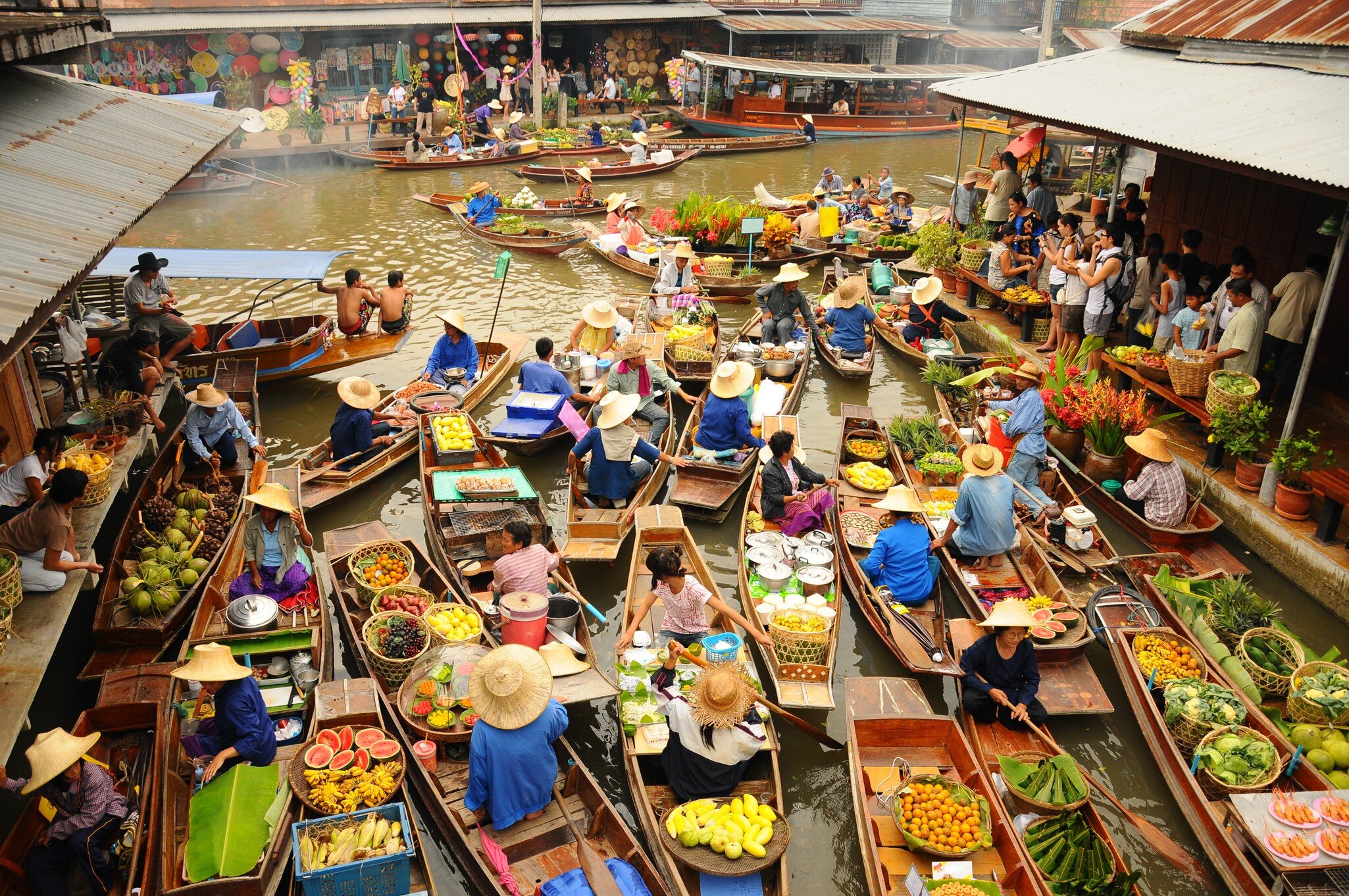 BANGKOK   APRIL 13: Wooden boats busy ferrying people at Amphawa floating market on April 13, 2011 in Bangkok. A traditional popular method of buying and selling still practiced in Amphawa canals of Thailand.