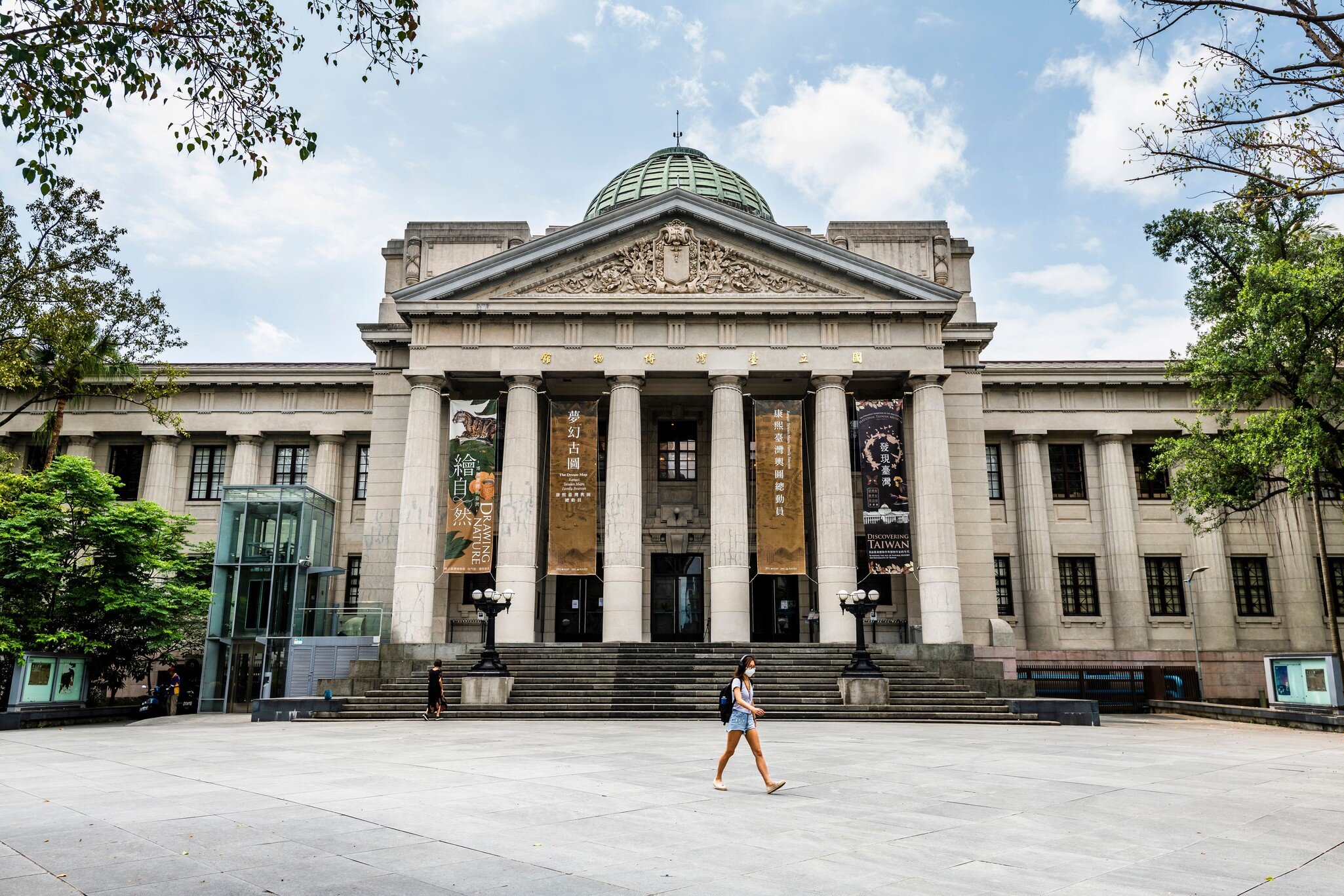 A girl walks in front of the Romanesque columned facade of the National Taiwan Museum in Taipei.
