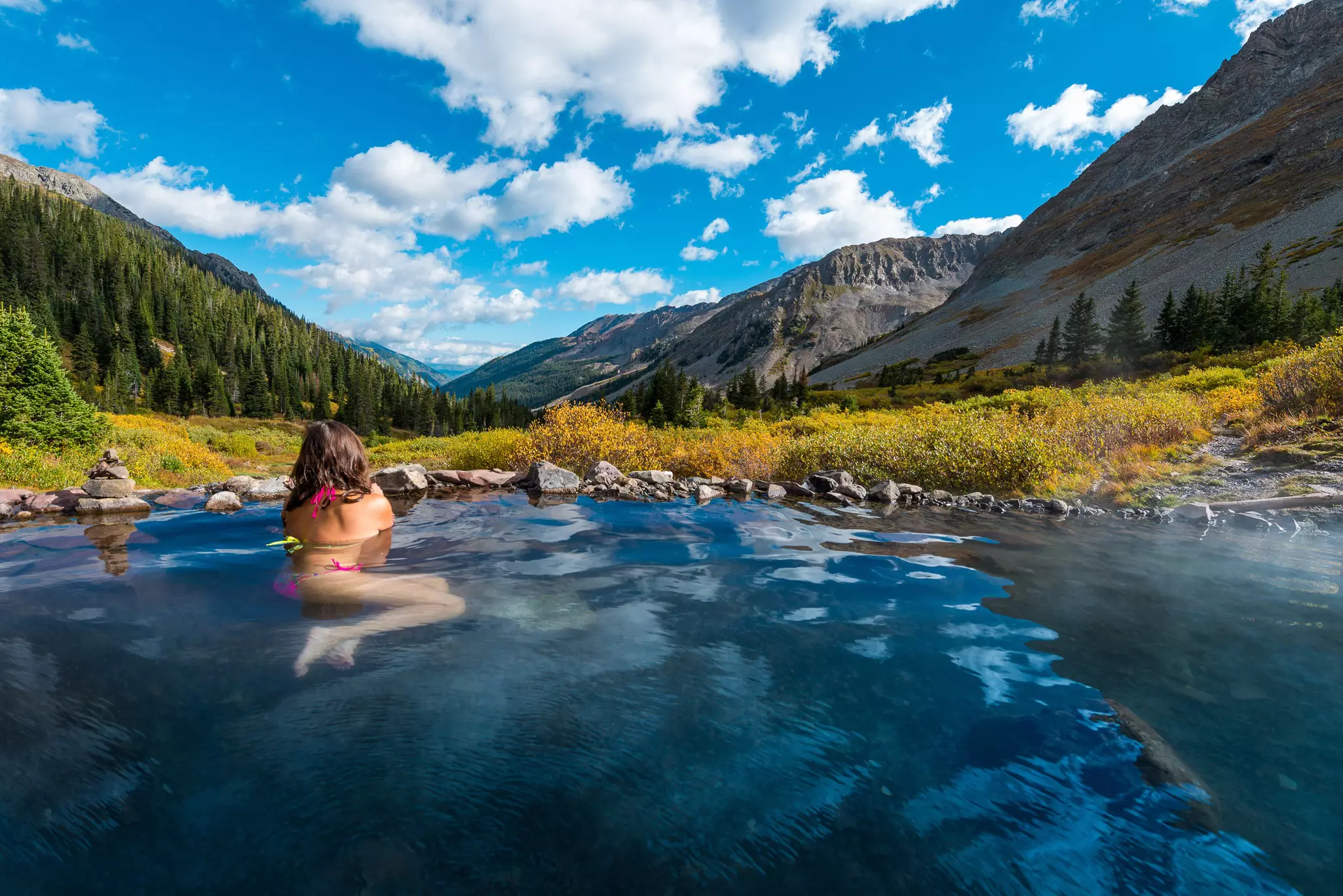 Woman relaxing in hot spring pool Conundrum Hot Springs near Aspen Colorado