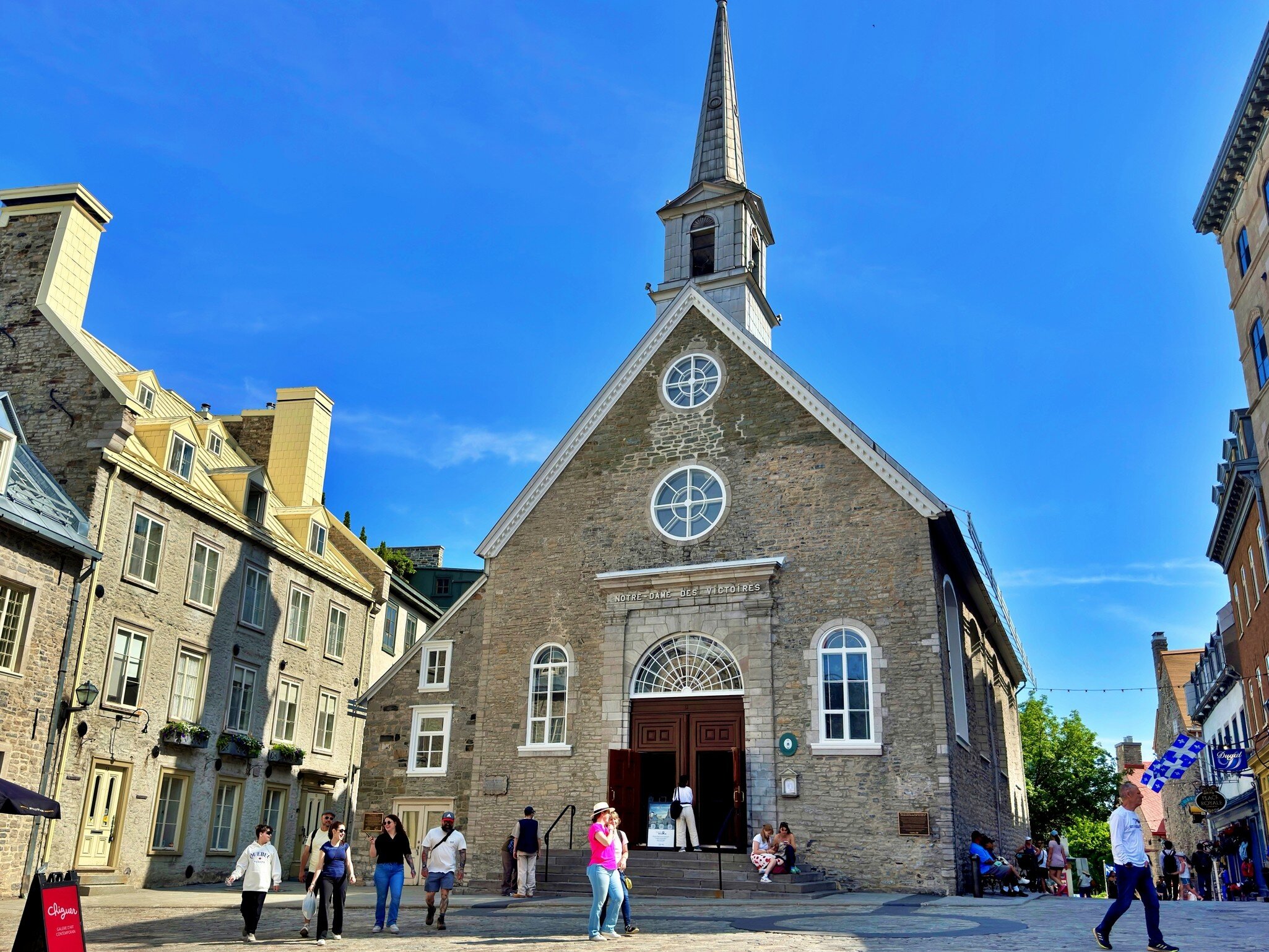 Quebec, Canada - Jun 25, 2025: Wide view of Notre Dame des Victoires Church in Place Royale surrounded by historic stone buildings and tourists visiting Old Quebec., License Type: media, Download Time: 2026-09-16T20:18:31.000Z, User: LP_NZhan, Editorial: true, purchase_order: 65050 - Digital Destinations and Articles, job: App Content, client: Lonely Planet App, other: Nadine Zhan 