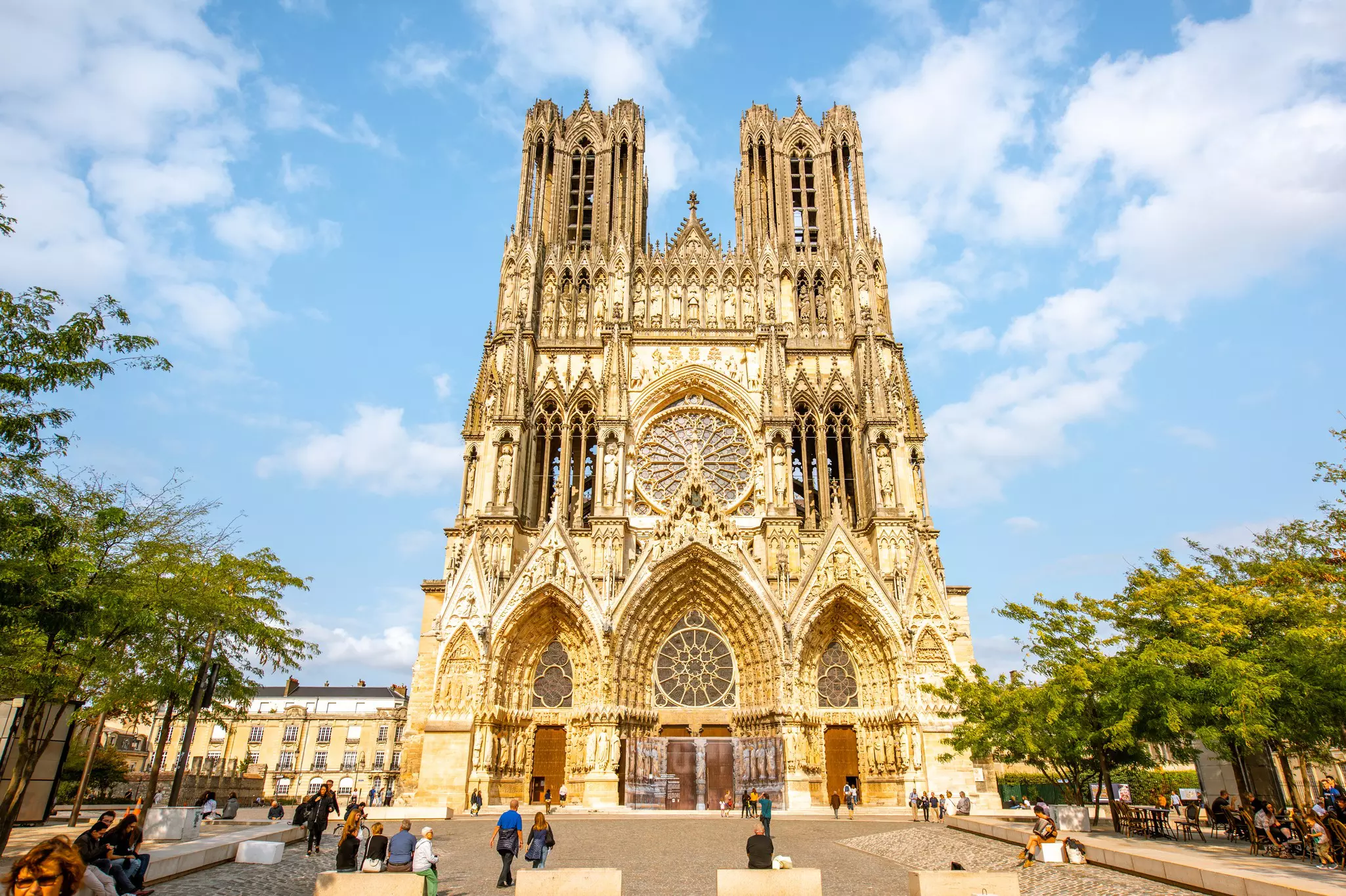 View on the crowded square near the famous Notre-Dame cathedral in Reims city, France.