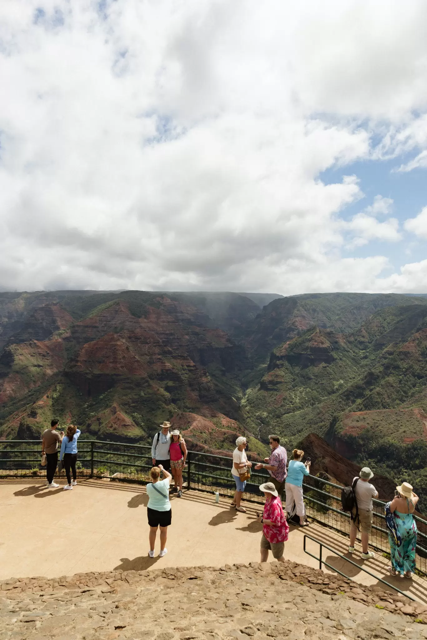 People at a viewpoint looking over a canyon landscape: Waimea Canyon, Kauaʻi, Hawaii