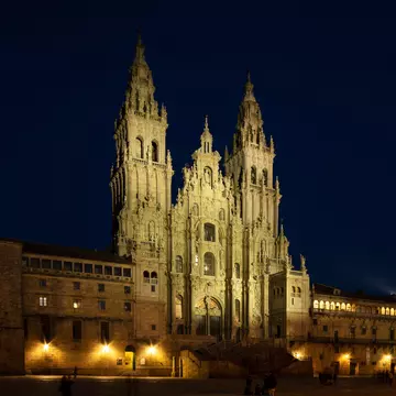 View of the facade of the Catedral de Santiago de Compostela at night in Spain.