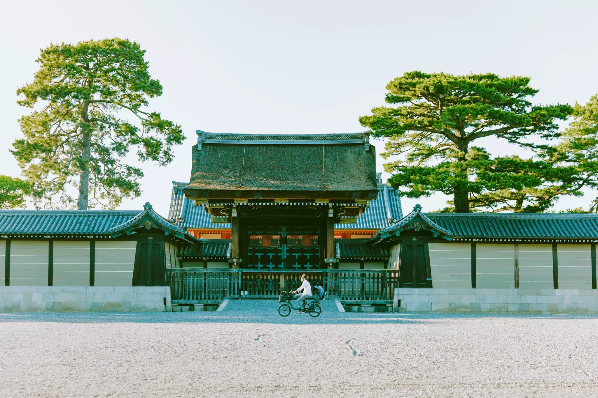 A cyclist rides past a historic structure in Japan.