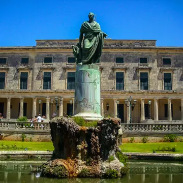 A large mansion, with white walls, arched windows and a manicured lawn is seen under a brilliant blue sky © felixmizioznikov / Getty Images