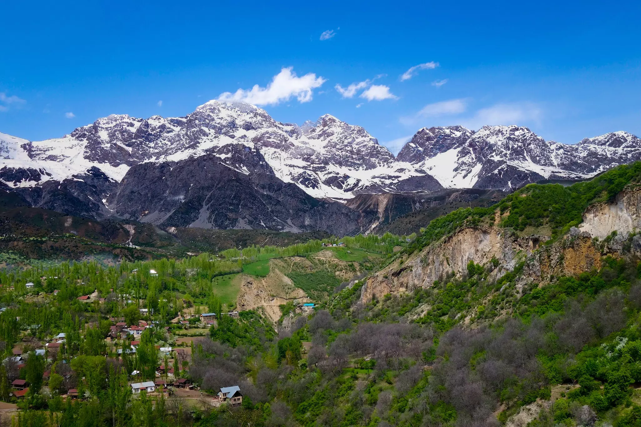 View over the town and walnut forests of Arslanbob village in southern Kyrgyzstan, with mountains in the background