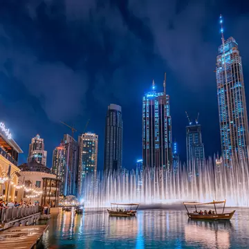Dubai, United Arab Emirates - January 3, 2022: People enjoy a boat ride while watching a performance of the Dubai Fountain at night, with the skyscrapers of Dubai in the background., License Type: media, Download Time: 2026-05-21T16:52:43.000Z, User: lonelyplanetmedia, Editorial: true, purchase_order: 65050 - Digital Destinations and Articles, job: Comp Ingestion, client: Global Publishing WIP, other: Pia Peterson