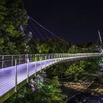 Illuminated Liberty Bridge in Falls Park downtown Greenville South Carolina on a starry night.