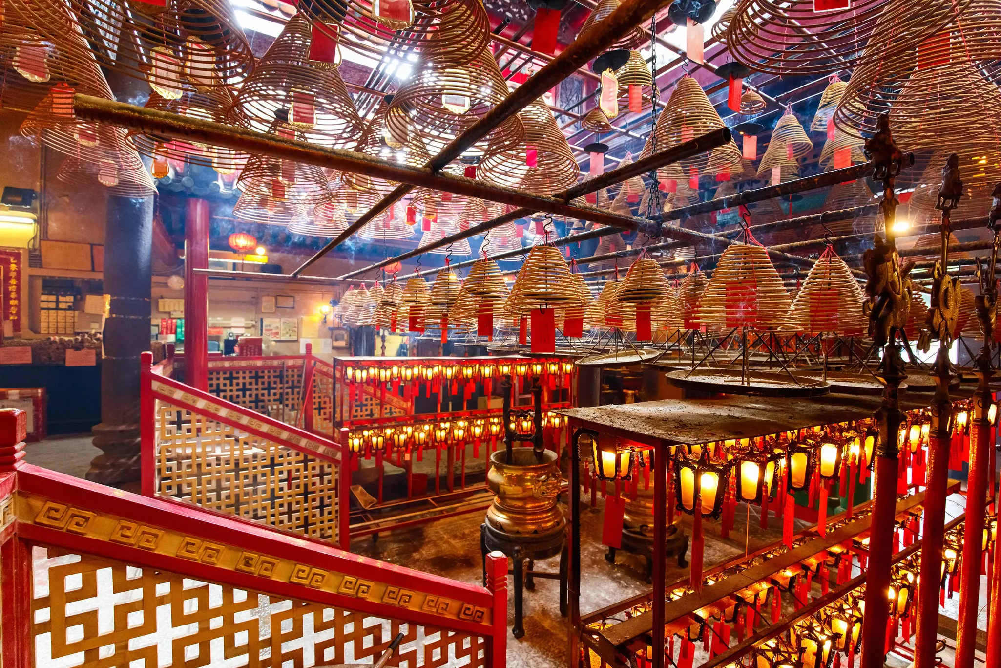 Interior of Man Mo Temple in Hong Kong with incense offerings and coils suspended from the ceiling.