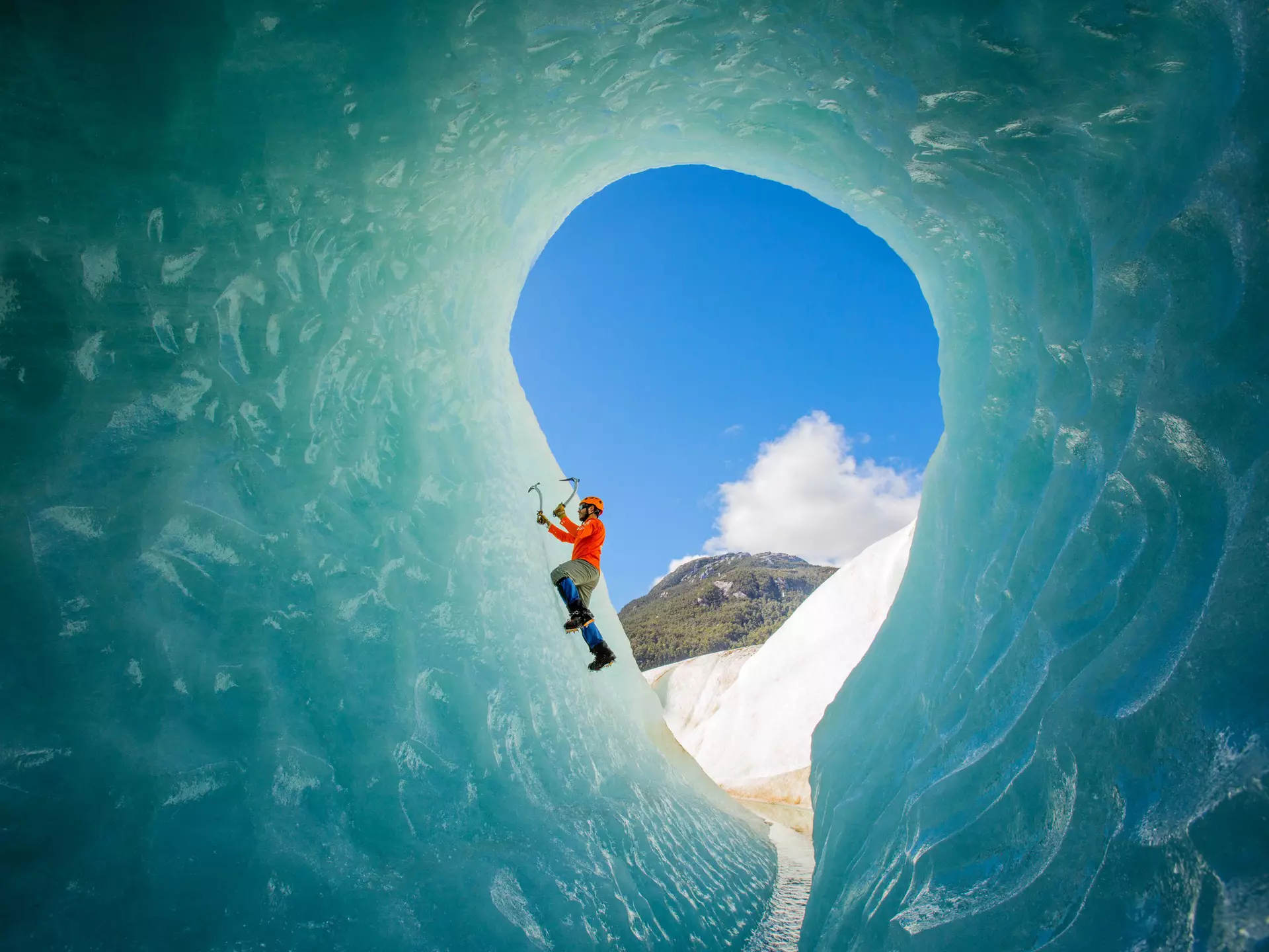 A solo male ice climber working his way up on an ice wall in a glacier. Lifestyle image created from the inside of an ice cave.
1215792551