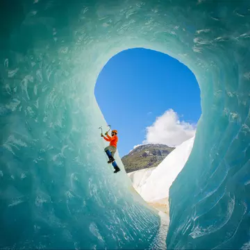 A solo male ice climber working his way up on an ice wall in a glacier. Lifestyle image created from the inside of an ice cave.
1215792551